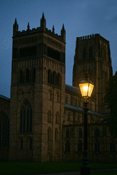 Night-time scene of a cathedral and street lamp.